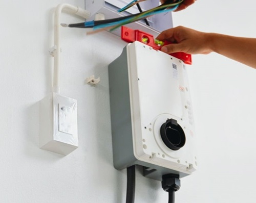 Electricien installant une borne de recharge